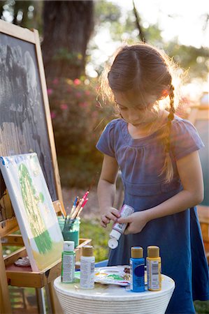 squeezing (compress) - Girl squeezing paint onto palette in garden Stock Photo - Premium Royalty-Free, Code: 649-09123714