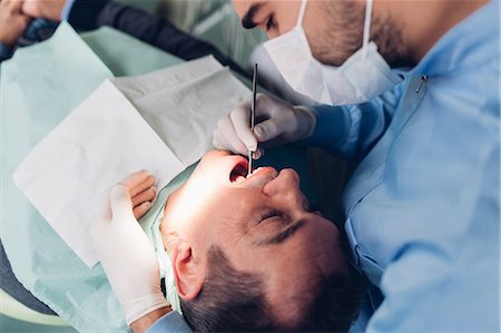 simsearch:614-07194617,k - Dentist looking into male patient's mouth, elevated view Stock Photo - Premium Royalty-Free, Code: 649-09138869