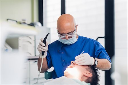 simsearch:614-07194617,k - Dentist carrying out dental procedure on male patient Stock Photo - Premium Royalty-Free, Code: 649-09138877
