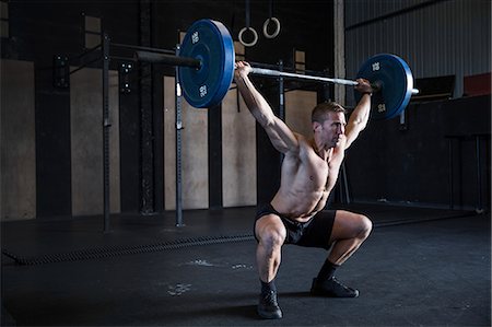 simsearch:649-09139139,k - Man exercising in gym, using barbell, front squat position Stock Photo - Premium Royalty-Free, Code: 649-09139127