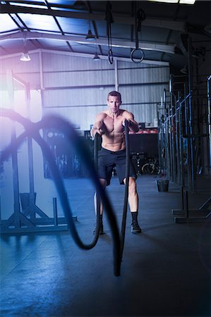 simsearch:649-09139139,k - Man exercising in gym, using battle ropes Stock Photo - Premium Royalty-Free, Code: 649-09139121