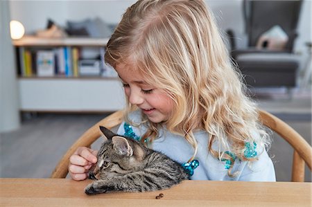 simsearch:649-09139263,k - Portrait of young girl, sitting at table, stroking pet cat Stock Photo - Premium Royalty-Free, Code: 649-09139234