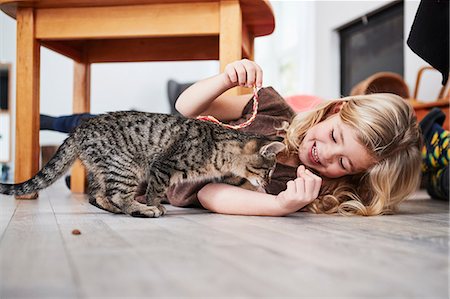 simsearch:6122-07695824,k - Young girl lying on floor, playing with pet cat Photographie de stock - Premium Libres de Droits, Code: 649-09139239