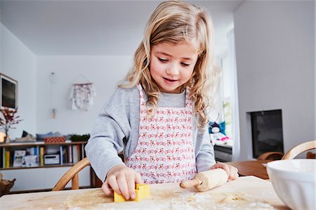 Young girl making cookies, using cookie cutter Stock Photo - Premium Royalty-Free, Code: 649-09139249