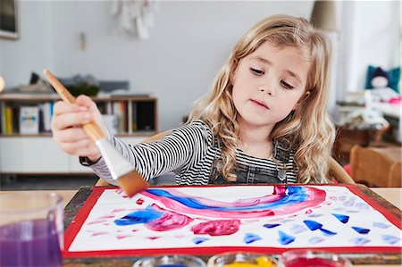 Young girl sitting at table, painting picture Foto de stock - Royalty Free Premium, Número: 649-09139241