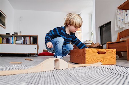 Young boy playing with toys in living room, low angle view Photographie de stock - Premium Libres de Droits, Code: 649-09139268