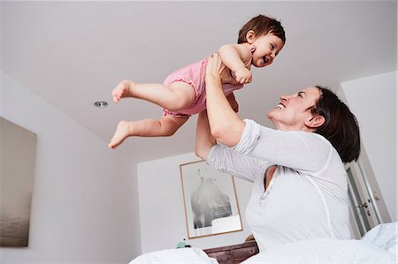 simsearch:700-06808775,k - Mother holding baby daughter in air, low angle view Photographie de stock - Premium Libres de Droits, Code: 649-09139261