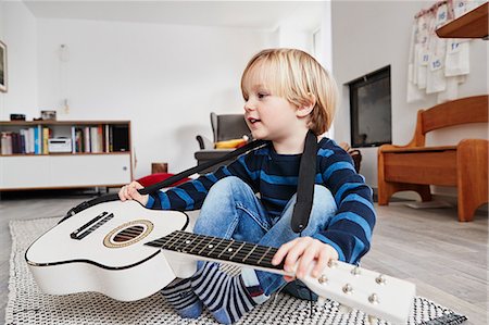 Young boy sitting with guitar around neck Photographie de stock - Premium Libres de Droits, Code: 649-09139270