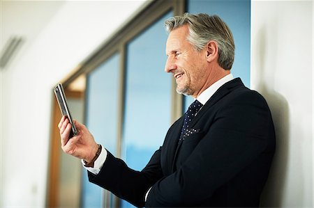 simsearch:614-06814076,k - Senior businessman looking at smartphone in office Stock Photo - Premium Royalty-Free, Code: 649-09139288