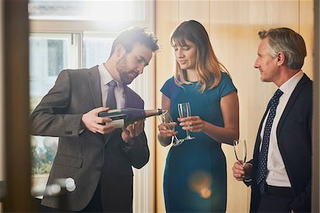 picture of champagne bottle and champagne flute - Businessman pouring champagne at office celebration Stock Photo - Premium Royalty-Free, Code: 649-09139306