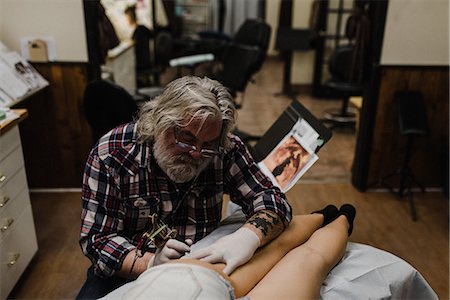 Tattooist tattooing young woman's thigh Stockbilder - Premium RF Lizenzfrei, Bildnummer: 649-09148444
