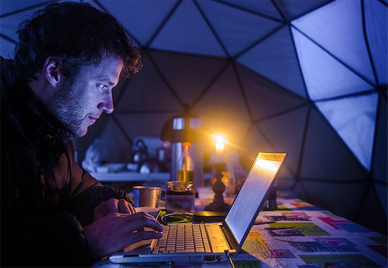 Man on expedition, using laptop in camp, Fletanes camp, Narsaq, Kitaa, Greenland Stock Photo - Premium Royalty-Free, Image code: 649-09148460