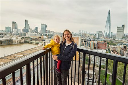 Woman and toddler daughter on balcony with London skyline, portrait Fotografie stock - Premium Royalty-Free, Codice: 649-09148597