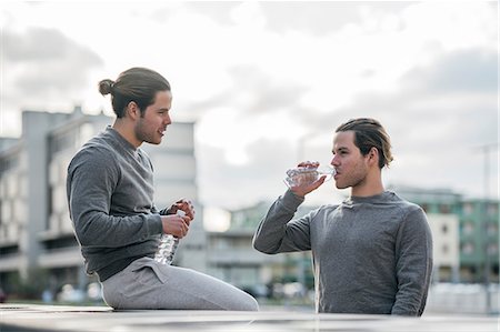 simsearch:649-09111293,k - Young adult male twins taking a training break, drinking water Fotografie stock - Premium Royalty-Free, Codice: 649-09148649