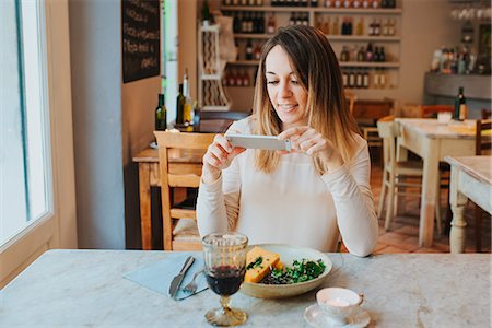 Woman taking photo of vegan meal in restaurant Stock Photo - Premium Royalty-Free, Code: 649-09148679