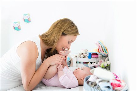 sitting holding legs up - Mother playing with baby on changing table Stock Photo - Premium Royalty-Free, Code: 649-09148784