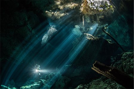 sobrecogimiento - Male diver diving in underground river (cenote) with sun rays and rock formations, Tulum, Quintana Roo, Mexico Foto de stock - Sin royalties Premium, Código: 649-09148842