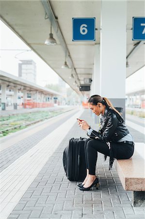 simsearch:649-09148924,k - Woman sitting on train platform, using smartphone, suitcase beside her Stockbilder - Premium RF Lizenzfrei, Bildnummer: 649-09148899