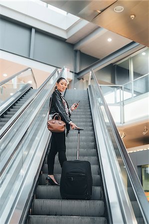 simsearch:649-09148924,k - Woman on escalator, holding wheeled suitcase and smartphone, low angle view Stockbilder - Premium RF Lizenzfrei, Bildnummer: 649-09148902
