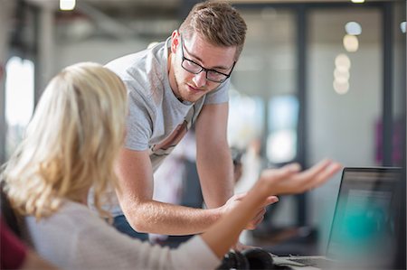 simsearch:649-09149094,k - Male and female colleagues talking at office desk Stock Photo - Premium Royalty-Free, Code: 649-09149090