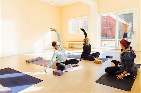 simsearch:6115-07539714,k - Teacher and women practicing sukhasana yoga pose in yoga studio Stock Photo - Premium Royalty-Free, Code: 649-09155639