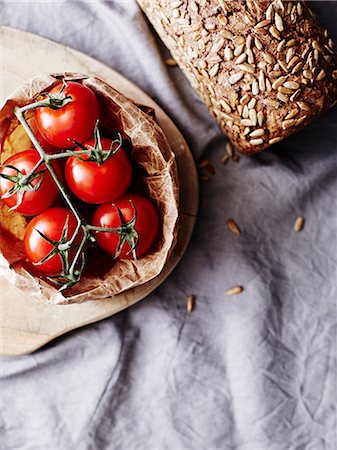 Still life of rye bread and vine tomatoes, overhead view Stock Photo - Premium Royalty-Free, Code: 649-09155992