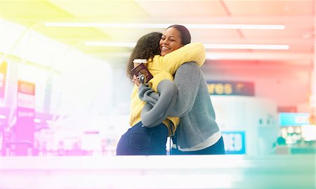 simsearch:649-08824511,k - Two mid adult women hugging in airport departure lounge Stock Photo - Premium Royalty-Free, Code: 649-09156208