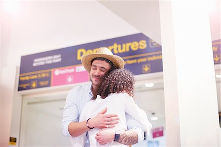 people hugging at airport - Man and woman hugging at departure lounge of airport Stock Photo - Premium Royalty-Free, Code: 649-09156231
