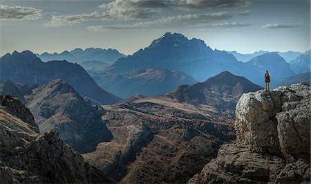 Climber on cliff looking at mountain ranges, Dolomites, Cortina d'Ampezzo, Veneto, Italy Photographie de stock - Premium Libres de Droits, Code: 649-09156248