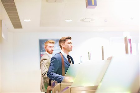 Two men walking through security gate at airport, side view Fotografie stock - Premium Royalty-Free, Codice: 649-09156284