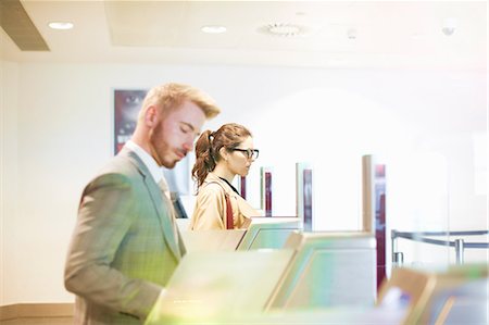 Businessman and woman walking through security gate at airport, side view Foto de stock - Sin royalties Premium, Código: 649-09156286