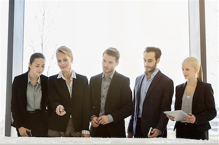 Businesswomen and men looking down at architectural model Stock Photo - Premium Royalty-Free, Code: 649-09156387