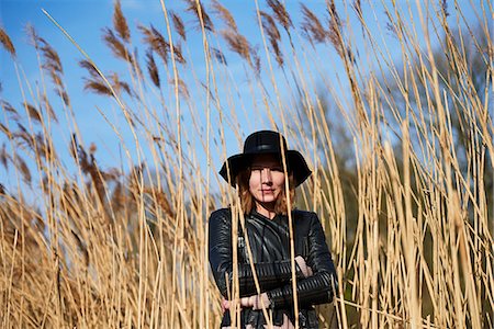 Cool woman wearing felt hat standing among reeds, portrait Photographie de stock - Premium Libres de Droits, Code: 649-09156410