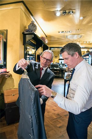 simsearch:649-09158921,k - Tailor showing customer bespoke jacket in tailors shop Photographie de stock - Premium Libres de Droits, Code: 649-09158914