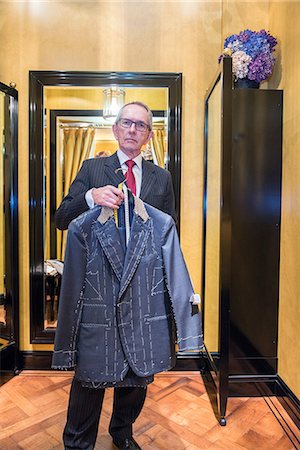 simsearch:649-09158921,k - Tailor holding unfinished bespoke jacket in tailors shop, portrait Photographie de stock - Premium Libres de Droits, Code: 649-09158916