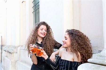simsearch:400-08831347,k - Fashion blogger twins toasting with cocktail by building Stock Photo - Premium Royalty-Free, Code: 649-09159114