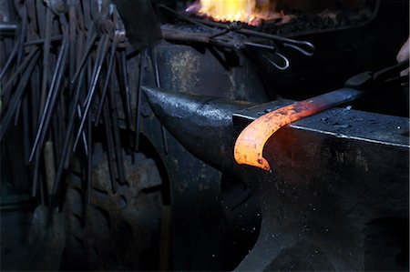 Red hot metal on anvil in blacksmiths shop Foto de stock - Sin royalties Premium, Código: 649-09159350