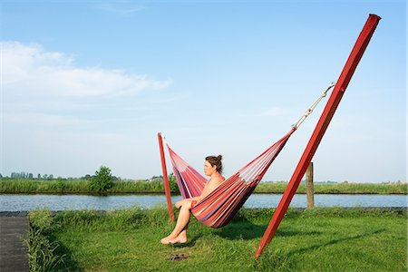 simsearch:649-06844490,k - Woman relaxing in hammock by river, Broek, Friesland, Netherlands Foto de stock - Sin royalties Premium, Código: 649-09159465