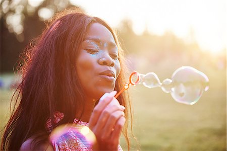 rural fair - Young woman covered in coloured chalk powder blowing bubbles at Holi Festival Stock Photo - Premium Royalty-Free, Code: 649-09166413