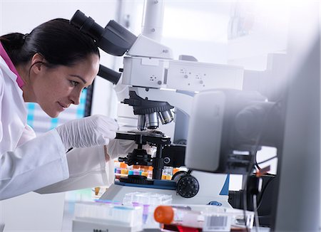 Scientist viewing human sample on glass slide under microscope Photographie de stock - Premium Libres de Droits, Code: 649-09166691