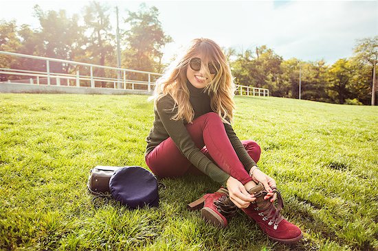 Portrait of blonde haired woman wearing sunglasses sitting on grass, looking at camera smiling Stock Photo - Premium Royalty-Free, Image code: 649-09166737