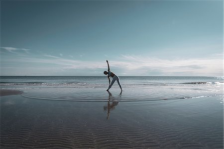 simsearch:614-08641700,k - Woman practising yoga on beach Photographie de stock - Premium Libres de Droits, Code: 649-09166864