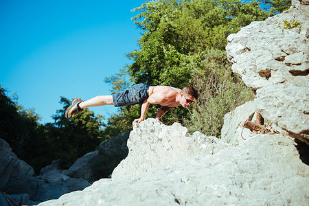 Man balancing on hands by stream, Arezzo, Toscana, Italy Stock Photo - Premium Royalty-Free, Code: 649-09176739