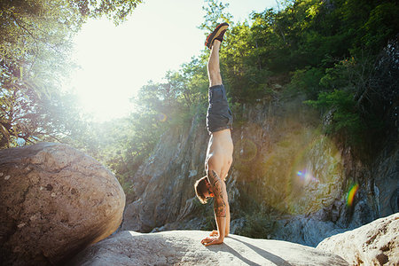 Man doing handstand on rock, Arezzo, Toscana, Italy Stock Photo - Premium Royalty-Free, Code: 649-09176744