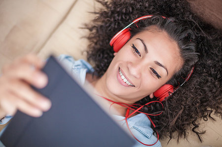 Woman listening to music on digital tablet at home Photographie de stock - Premium Libres de Droits, Code: 649-09176892