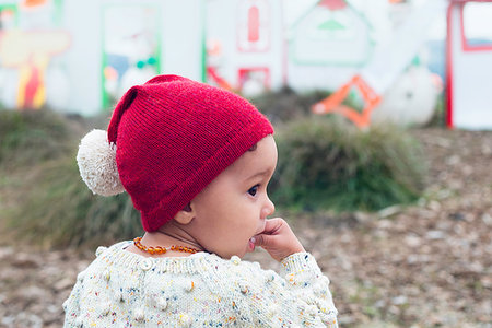 finger in mouth - Toddler in red beanie with pom pom Photographie de stock - Premium Libres de Droits, Code: 649-09182059