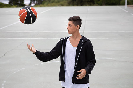 simsearch:649-09182176,k - Male teenage basketball player on basketball court throwing and catching ball Foto de stock - Sin royalties Premium, Código: 649-09182152