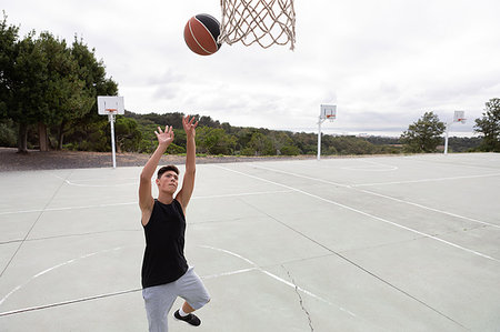 Male teenage basketball player throwing ball toward basketball hoop Fotografie stock - Premium Royalty-Free, Codice: 649-09182172