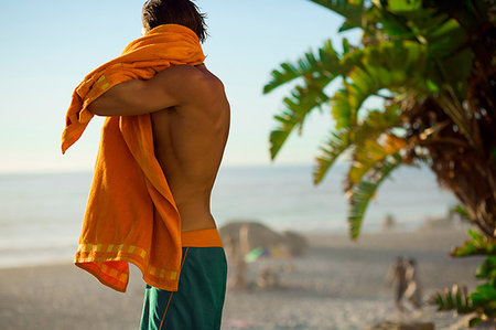 Mid adult male surfer drying off on beach, Camps Bay Beach, Cape Town, South Africa Foto de stock - Royalty Free Premium, Número: 649-09182319