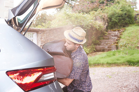 punching bag - Young man in trilby removing luggage from car boot outside hotel Stock Photo - Premium Royalty-Free, Code: 649-09182436